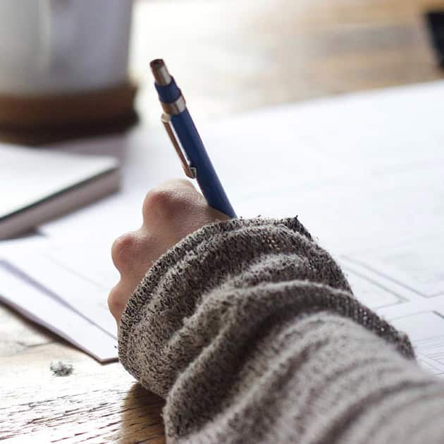 Someone writing down ideas for the Fall Fiction Contest