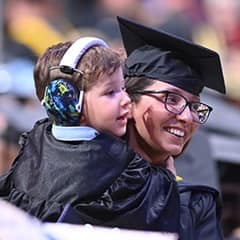 SNHU graduate holding her son at the 2025 spring Commencement