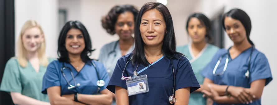 6 nurse leaders wearing medical scrubs and stethoscopes