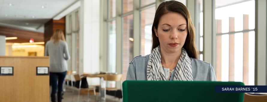 SNHU grad, Sarah Barnes, working on her laptop. With the text Sarah Barnes '15