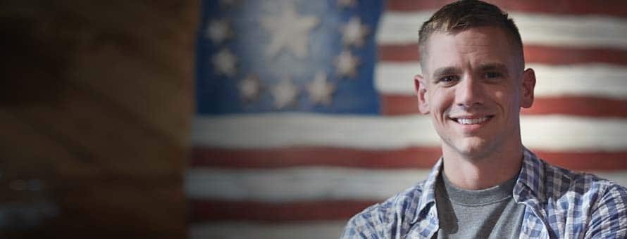 SNHU student standing in front of flag