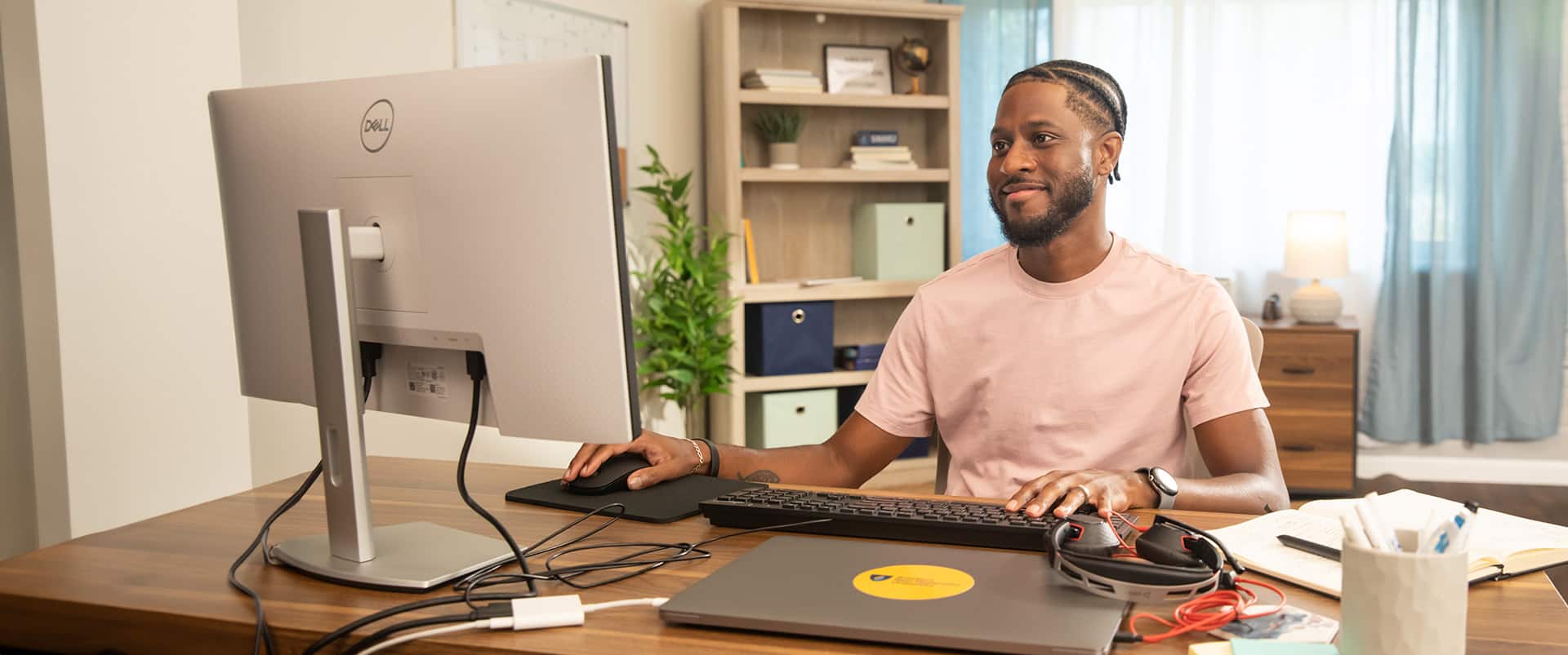 Matthew Seawright, who earned his degree from SNHU in 2019, sitting at a desk in an office working on his computer with a closed laptop on the desk.