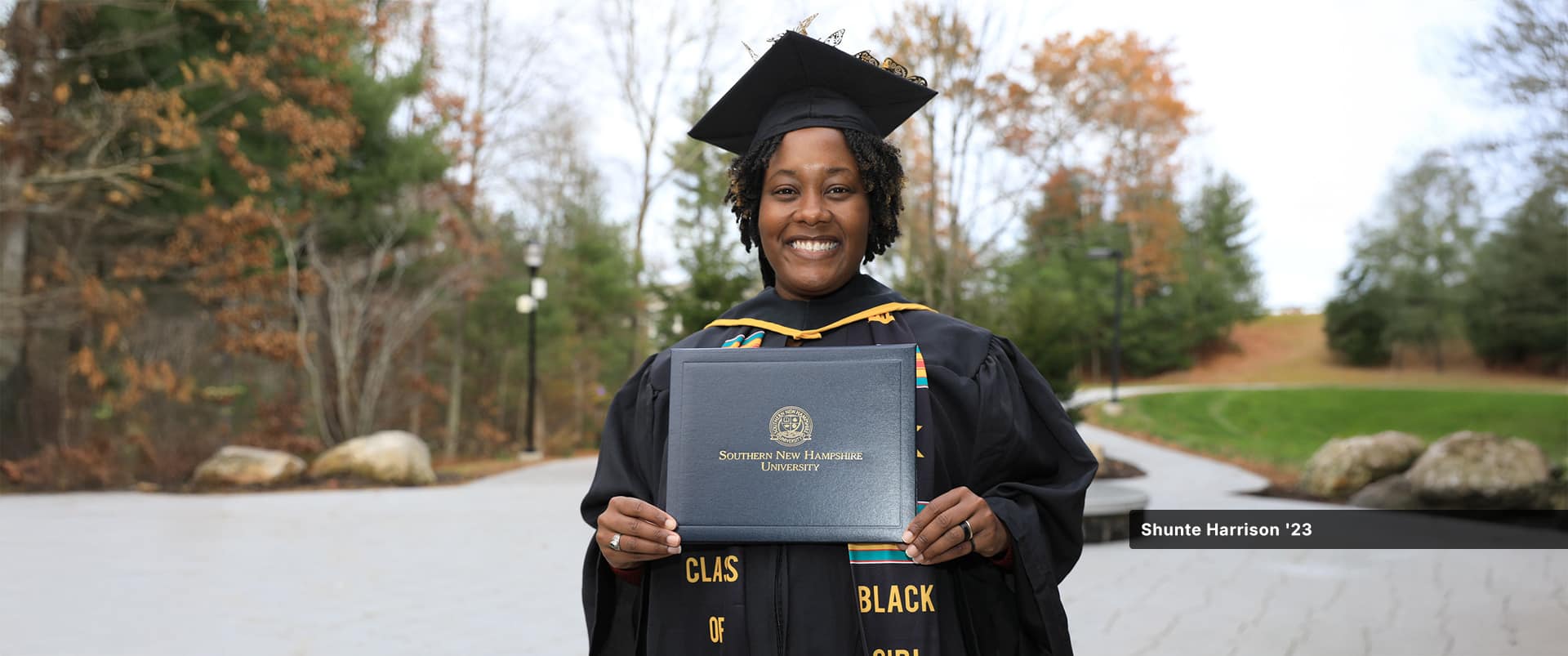Shunte Harrison, who earned her associate in criminal justice from SNHU in 2023, wearing her cap and gown and holding her diploma.