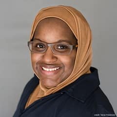 Ashely Franklin, an instructor of English Composition at SNHU wearing a brown headscarf and eyeglasses.