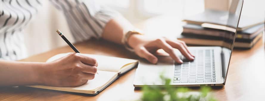 A person holding a pencil, taking notes on how to teach writing.