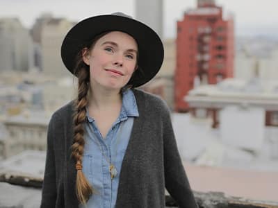 2015 SNHU alumna Audrey Greathouse in front of a city skyline.