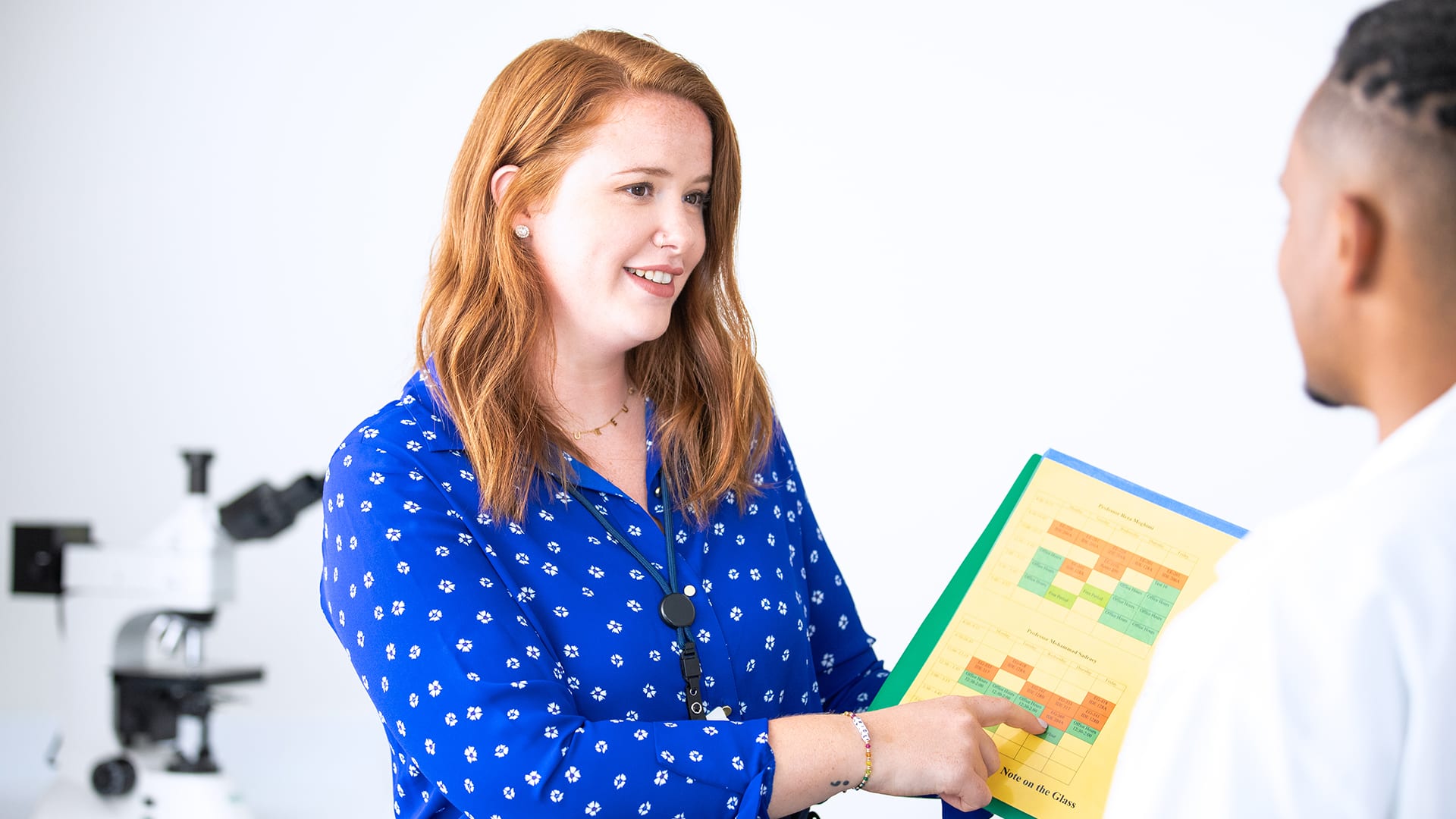 Ali Rule Lamoureux, who earned her degree from SNHU, pointing to a chart she's holding while talking to a man.