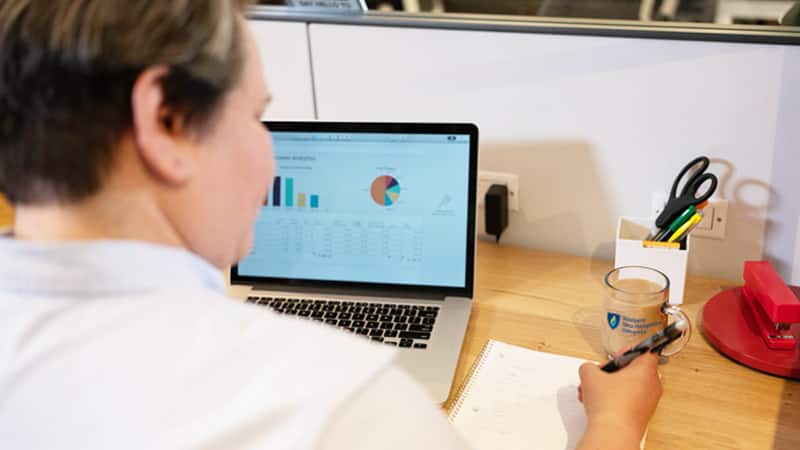 Alaine Garcia, a 2020 online alumna, working on a pie chart on a laptop.