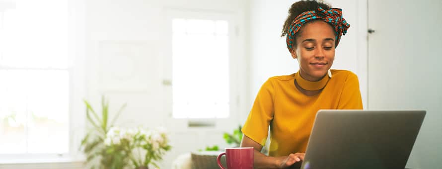 A person using a laptop, researching how long it takes to get her bachelor's degree online.