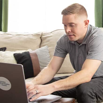 A laptop writing pad and cup of coffee on a desk.