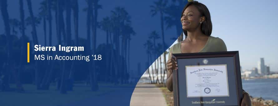 Sierra Ingram standing and holding her framed master's in accounting degree from SNHU.