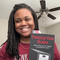 Brittany Armstead, an academic advisor at SNHU, holding a book