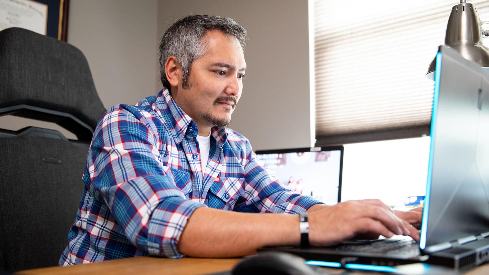 SNHU graduate sitting at a desking using a computer