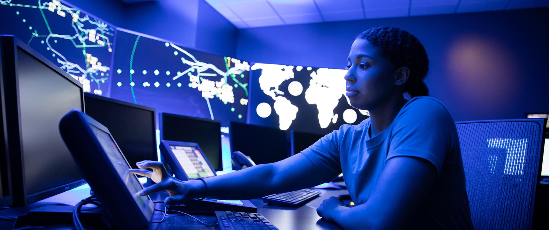 Bethanie Thomas, working from a high-tech office space with digital maps and coordinates on the walls all around her.