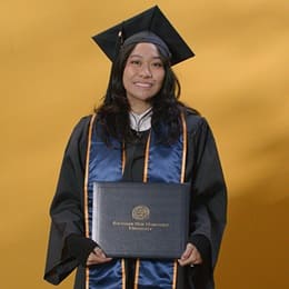 Carlene Estigoy, an SNHU graduate with a bachelor's in psychology, wearing a graduation cap and gown.