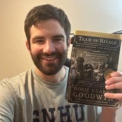 Christian Renzi, senior content creator video editor at SNHU, holding a book