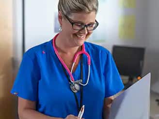 Kristina Libby, 2017 graduate of SNHU’s BS in nursing program, smiling while wearing scrubs and a stethoscope.