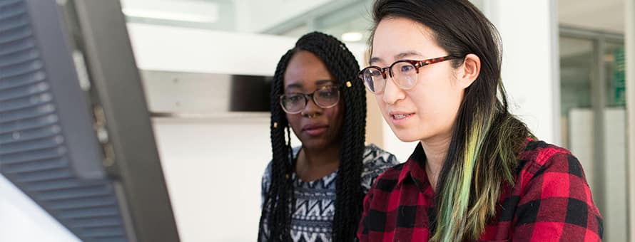 Two students at an Hour of Code event practicing their coding literacy