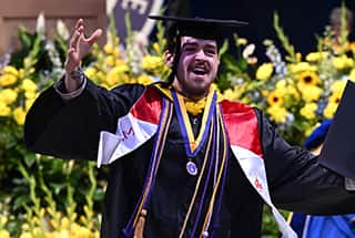 2025 Spring graduate celebrating after getting his diploma.