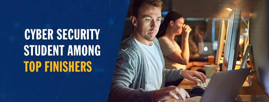 Man working one a laptop computer in a dimly lit room.