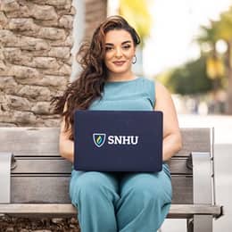 Deonna Purrazzo sitting on a bench with an SNHU laptop.