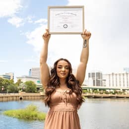 Deonna Purrazzo holding up her SNHU diploma.