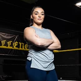 Deonna Purrazzo standing with her arms folded in the wrestling gym.