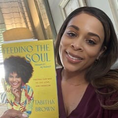 Dr. Jolivette Wallace, an associate dean of business at SNHU, holding "Feeding the Soul" by Tabitha Brown.