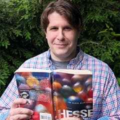Dr. Matthew Schandler, an instructor of history at SNHU, holding "The Glass Bead Game" by Hermann Hesse.