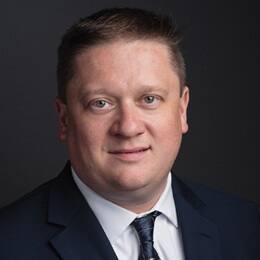 SNHU associate dean of liberal arts Dr. Robert Denning wearing a dark suit and blue tie.