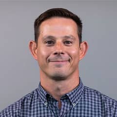 Ed Brillant, game design coordinator at SNHU, in a button-down plaid shirt.