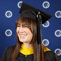 Emily Bevens, a 2023 SNHU graduate with a master’s degree in forensic psychology, dressed in a graduation cap and gown.