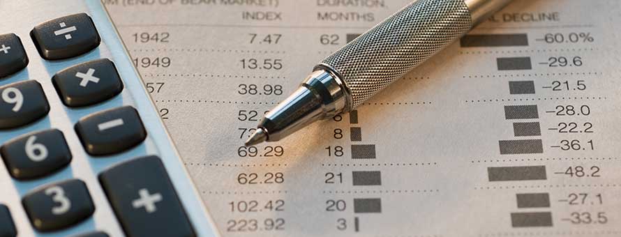 A pen and calculator resting on a report used by a forensic accountant