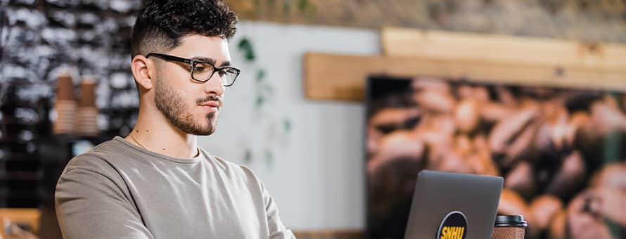Naeem Jaraysi using a laptop to earn his marketing degree at SNHU