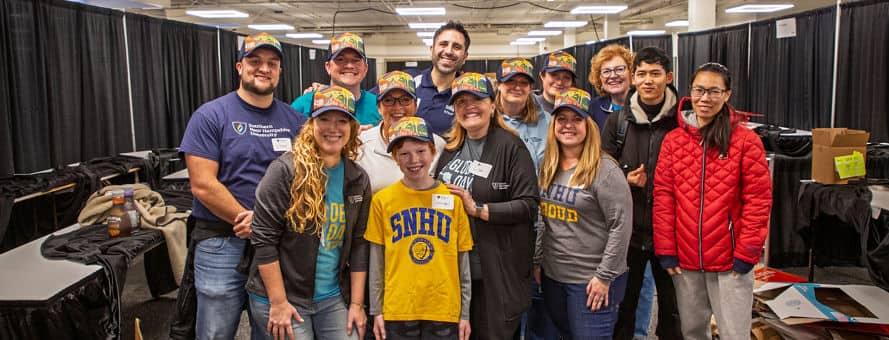 A group of 13 Global Days of Service volunteers, including SNHU President Lisa Marsh Ryerson, center, who supported the New Hampshire Food Bank.