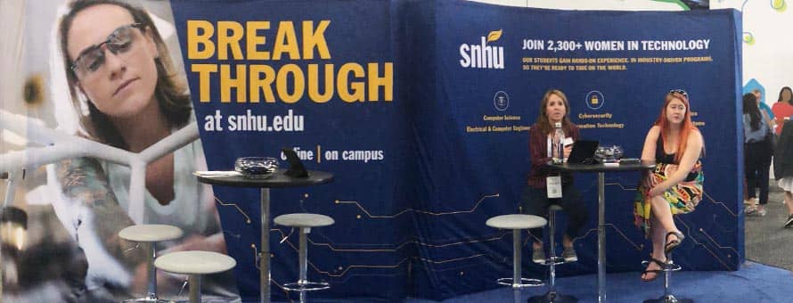 Two women at SNHU's booth at the Grace Hopper Celebration.