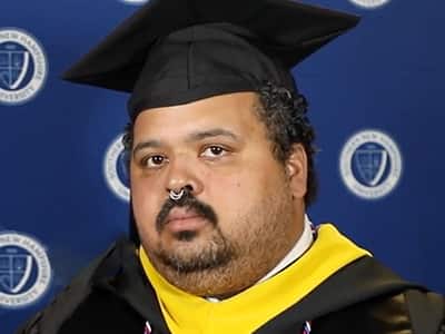 Gregory Tolson, who earned his bachelor's in computer information systems in 2023, wearing his cap and gown.
