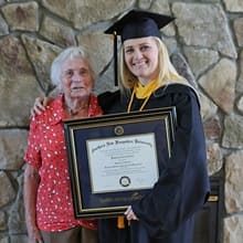Kimberly Cartier wearing a cap and gown 