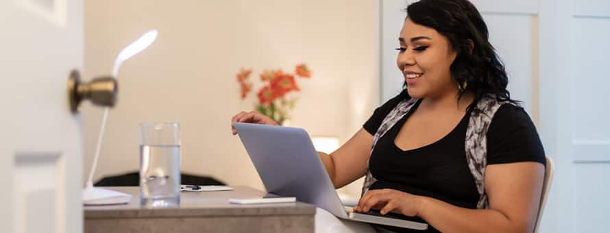 An adult learner discovering how online courses work, sitting at a desk with a laptop.