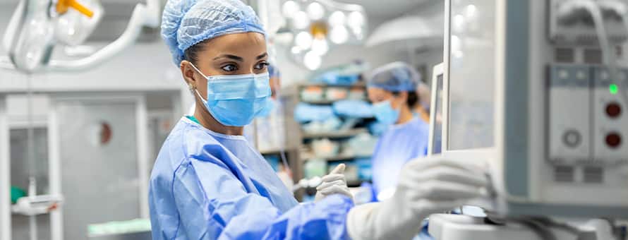 A nurse anesthetist working on a machine