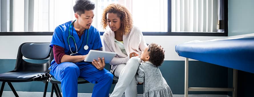 A CNA sitting with a patient and a small child, explaining something on a tablet