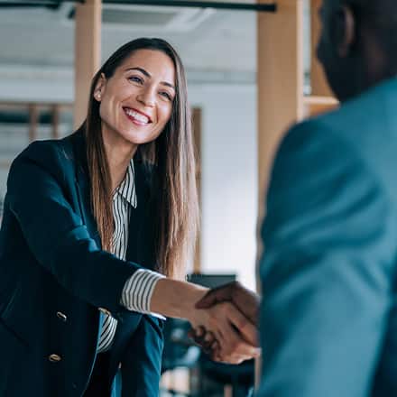 A job candidate shaking hands with an employer after learning how to change careers.