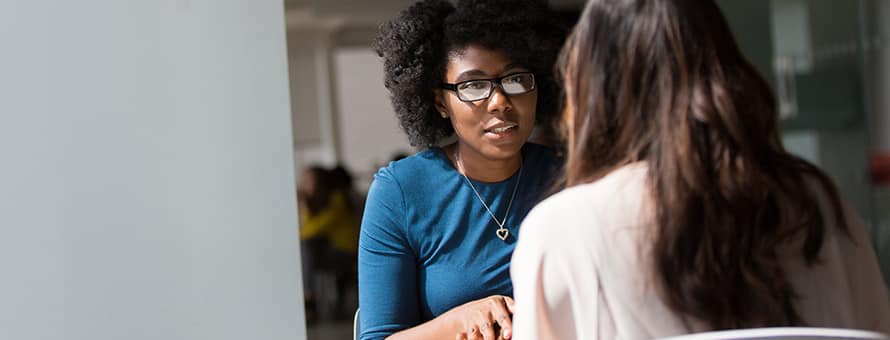 Two professionals discussing how to give feedback and what equity has to do with it