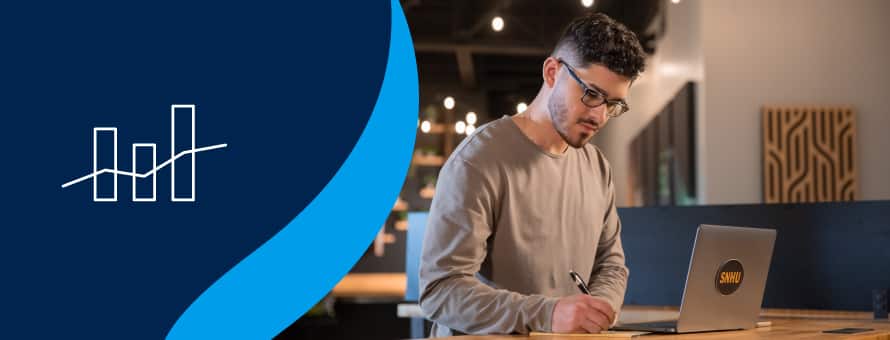 Naeem Jaraysi, who earned his master's degree in marketing at SNHU, taking notes from his laptop to the left of an icon showing data