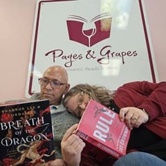 James Jones '23 and Heather Wejroch '23, SNHU graduates reading books under a Pages and Grapes sign in the store.