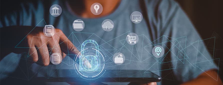 A person using a tablet with icons hovering in the air, including a blue lock to represent cybersecurity.