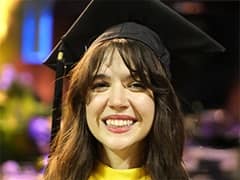 Katlyn Genovese, who earned her bachelor's in criminal justice from SNHU in 2023, wearing her graduation cap and smiling.
