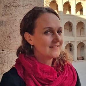 Dr. Kelley Sams, an adjunct instructor in SNHU's online master's in public health program, wearing a large red scarf.