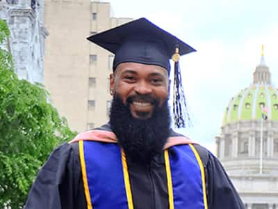 Kemar Reid, who earned his online master's in public health from SNHU in 2020, wearing his cap and gown.