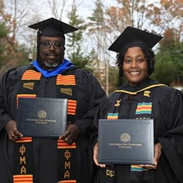 Korey Harrison, left, and Shunte Harrison, right, dressed in their SNHU graduation cap and gown.